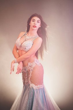 Kadın cinsel yarı çıplak vücut poz egzotik kostüm portresi. Mavi arka plan parlayan seksi geleneksel Oryantal Dansöz kız. Müslümanlar, günaha kavramı.