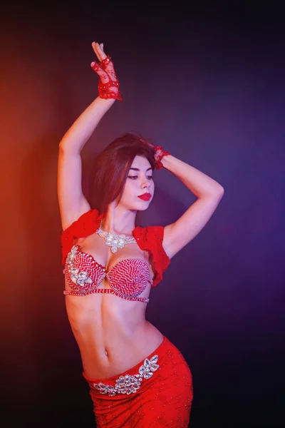 Femme en costume rouge brillant exotique bouge sexuellement son corps. Sexy danseuse orientale traditionnelle du ventre dansant sur fond de fumée néon. Musulmans, concept de tentation — Photo