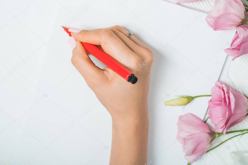 Calligrapher student practices in writing lettering with red marker on canvas. Creative artist freelancer working on project at home studio. Handwriting concept.