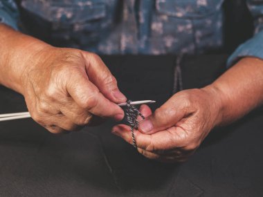 Yaşlı kadının yün iplik kazak ya da eşarp kış için örgü kırışıklıklar ile el kapatın. Büyükanne evde dokuma kumaşlar. Giysi yapma işlemi. Hobi kavramı.