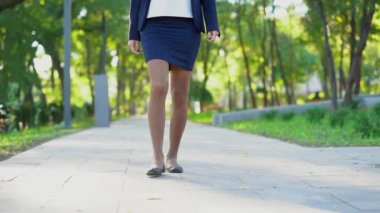 Tanınmayan genç iş kadını resmi aşınmaya yalnız yeşil parkta yürüyüş bacaklar. İş ya da üniversite kız tutar.