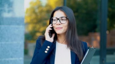 İş kadını cep telefonuyla konuşma var. İş kız gözlük ve resmi takım memnuniyetle meslektaşı ile konuşuyor. Ofis çalışanı, ücret çalışan, hafta içi kavramı