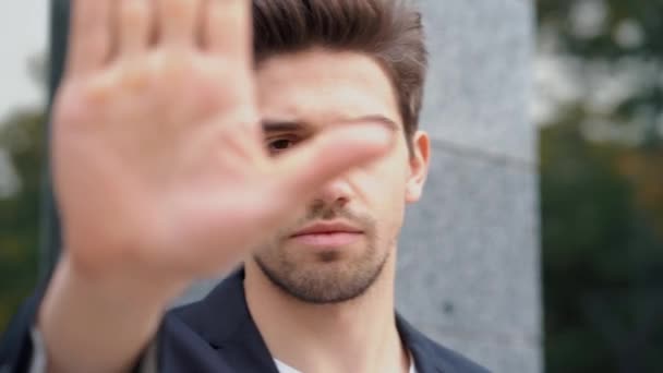 Портрет молодого бизнесмена с жестом неодобрения рукой: знак отрицания, без знака, негативный жест закрывает камеру рукой, профессиональный менеджер в костюме — стоковое видео