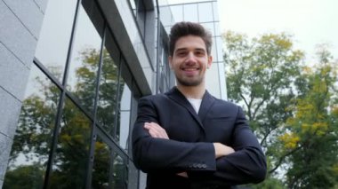 Arka bina Office şehirde genç başarılı işadamı portresi. Kameraya bakarak ve gülümseyen iş elbiseli adam. Portre yakışıklı bir adam. Steadicam 4k görüntüleri