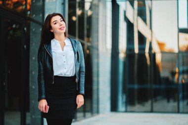 Mutlu genç iş kadını Ofis Binası yakınındaki portresi. Güzel beyaz öğrenci kız beyaz seksi bluz ayakta sokak sonbaharda