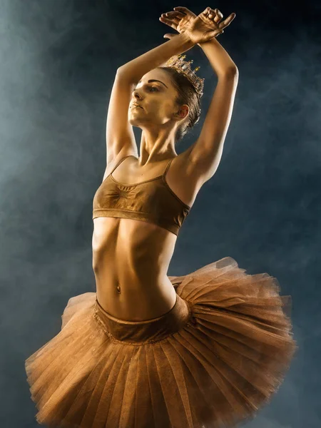 검은 바탕에 황금 피부를 빛나는와 아름 다운 젊은 발레 댄서의 초상화. 바디 아트 골드 페인트입니다. 투투 춤 연기 무대에 발레리 나 — 스톡 사진