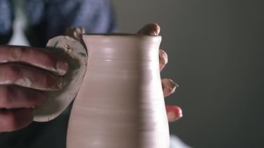 Potter şekiller kil ürün - kulplu testi - seramik araçları ile karşılaştı. Erkek el potters tekerlek üzerinde çalışma kapatın. Seramik vazo bitmedi aletlerden üzerinde iplik kadeh
