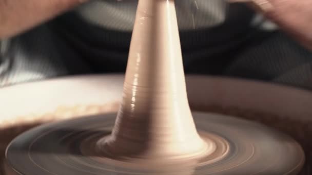 Ervaren potter vormen de klei product - jug - met aardewerk tools. Close up van mannelijke handen werken op potters wiel. Schot van half afgewerkte keramische vaas spinnen op jigger — Stockvideo