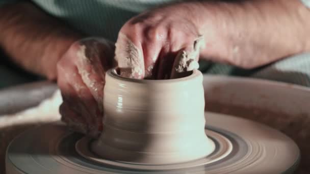 Het creëren van aardewerk en pottenbakken concept. Ervaren mannelijke pottenbakkers handen creëren prachtige clay product - bowl - met behulp van professionele gereedschappen. Getinte filmische, ambachtelijke fabriek authentiek — Stockvideo