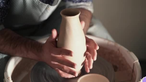 Deneyimli potter usta Clay - vazo - bitmiş ürün potters tekerlek kaldırır ve fırın veya fırın kavurma için hazırlar. 4k — Stok video