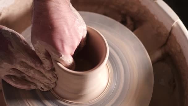 Ansicht des Menschen, der Topf auf Töpferscheibe macht. Töpfer formt das Tonprodukt - Vase oder Becher - mit professionellem Werkzeug, Draufsicht. Kleinunternehmer arbeitet in Werkstatt — Stockvideo