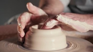 Toprak ve geleneksel seramik konsept oluşturma. Erkek potters eller güzel kil ürün - kase - profesyonel araçlar kullanarak oluşturma deneyimli. Tonda sinematik, zanaat fabrika otantik.