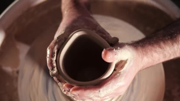 Vista dall'alto dell'uomo che fa la pentola sulla ruota della ceramica. Potter modella il prodotto in argilla - vaso o tazza - con strumenti professionali, vista dall'alto. Proprietario di piccole imprese che lavora in officina . — Video Stock