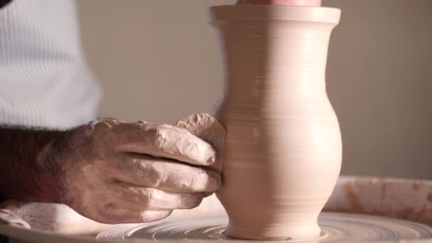 经验丰富的波特塑造粘土产品-壶-用陶器工具。关闭的男性手在波特轮工作。半成品陶瓷花瓶纺跳汰机的拍摄. — 图库视频影像