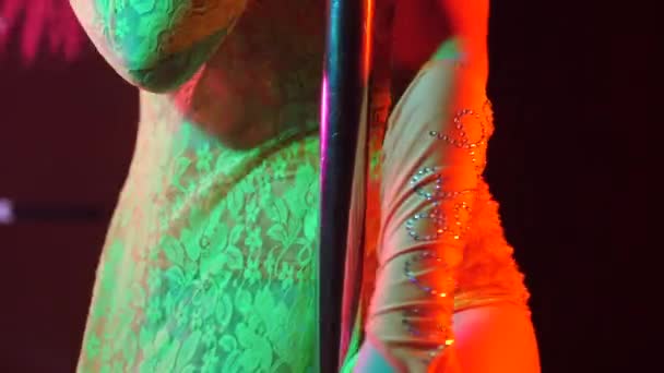 Mujer sexy en traje de encaje pedrería con piedras brillantes. Bailarina de striptease moviendo caderas en el escenario en un club nocturno con pilona. Stripper entretiene a los visitantes. Movimiento lento — Vídeo de stock