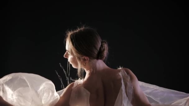 Baleriny praktykuje jej ruchy w ciemnym studio. Młoda dziewczyna taniec z powietrza biała sukienka tutu, wiruje wokół i uśmiecha się. Wdzięk i tkliwość w każdy ruch. — Wideo stockowe