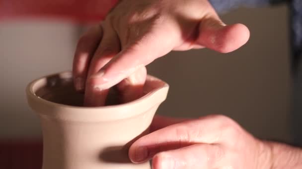 Potter vytváří džbán nos, pracuje na detaily a funkčnost produktu. Umělec pracuje rukama, které jemně vytváření správně tvarované ručně vyrobené z hlíny — Stock video