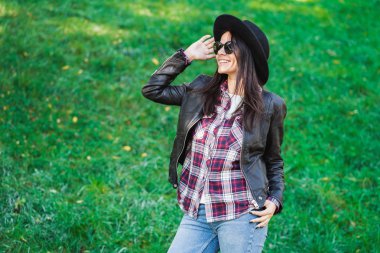 Şapkalı mutlu karışık yarış genç kadın portresi. İspanyol hippi kız parkta. Bayan giyen ekose gömlek ve güneş gözlüğü, trendy bir görünüm