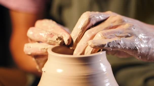 Artysta prowadzi ręce, które delikatnie tworzenia poprawnie w kształcie dzbanka ręcznie z gliny. Tradycyjnej ceramiki podejmowania, nauczyciel przedstawia podstawy ceramiki w studio sztuki. — Wideo stockowe