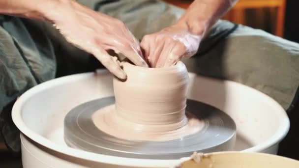 Potier expérimenté façonne le produit d'argile - cruche - avec des outils de poterie. Gros plan des mains masculines travaillant sur la roue des potiers. Tournage de vase en céramique semi-fini sur jigger — Video