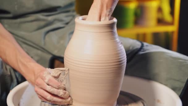 Художник управляет руками, которые аккуратно создают правильную форму ручной работы из глины. Традиционное керамическое производство, учитель показывает основы керамики в художественной студии — стоковое видео