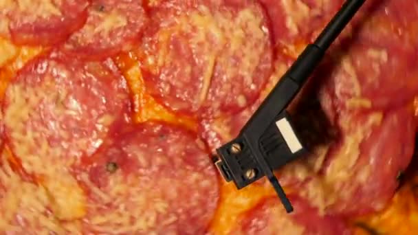 披萨意大利香肠旋转转盘乙烯基播放器。派对的概念, 美味的垃圾食品。意大利披萨配香肠和奶酪 — 图库视频影像
