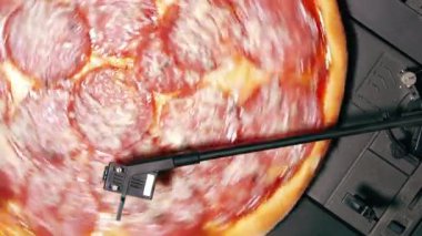 Pikap vinil oyuncu kayıt olarak iplik biberli pizza. Lezzetli lokanta ile parti kavramı. İtalyan mutfağının salam sosis ve peynir ile. Üstten görünüm.
