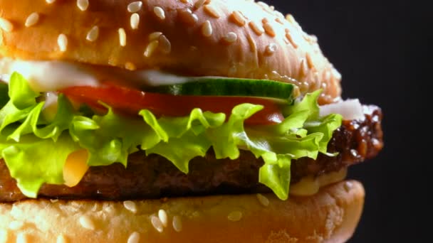 Свежий домашний гамбургер на гриле с мясной котлеткой, помидорами, огурцом, салатом, луком и кунжутом. Вкусная концепция быстрого питания. Нездоровый, вредный образ жизни. 4k — стоковое видео