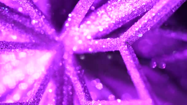 Ijs patroon vergrote weergave. Winter sneeuwvlok macro textuur achtergrond. Shining gloeiende Kerstboom speelgoed draaien in magische neon violet licht. Nieuwjaar feestelijke stemming. Slow motion — Stockvideo