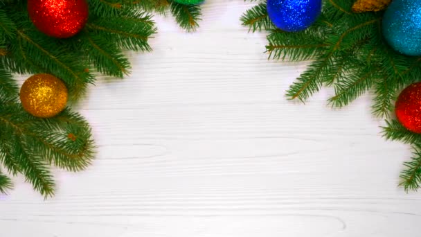 Hermoso fondo de vacaciones de ramas de abeto verde sobre una mesa de madera blanca decorada con bolas de Navidad. Vista superior. Copiar espacio. Feliz año nuevo 2019 — Vídeos de Stock