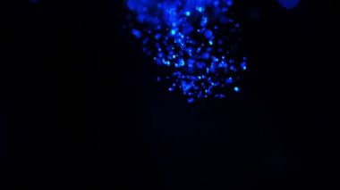 Suda parıldıyor. Su, soyut bulut formasyonları siyah zemin üzerine mavi glitter boya. Parlak geçişler, sanat modern projeler için eklendi olarak kullanılabilir. Ağır çekim