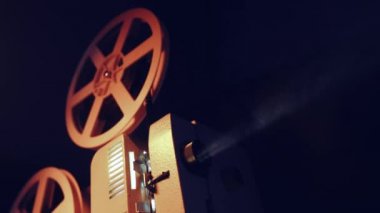 Vintage nesneleri Sinematografı kavramı. Karanlık odada oynayan retro film projektör. Eski moda antika süper 8 mm film projektör ışık demeti projelendirme. 4k.