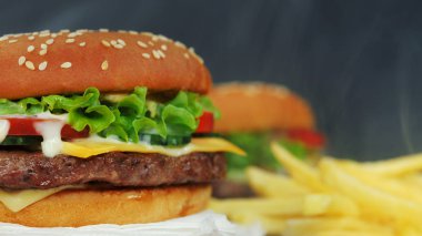 Büyük iştah açıcı burger et pirzola, sebze, peynir, salata ve sos ile. Hamburger diğer yemek arka plan üzerinde yakından görmek döner. Sağlıksız lezzetli yiyecek konsepti