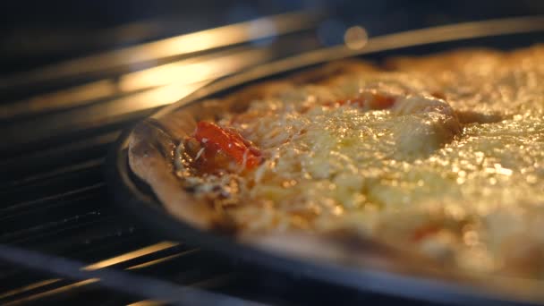 Kaas op pizza smelt van de hitte van oven. Bakken, ongezonde concept van de fast-food producten. Eten slecht voor figuur, huid, hart en tanden. Close-up. 4k. — Stockvideo