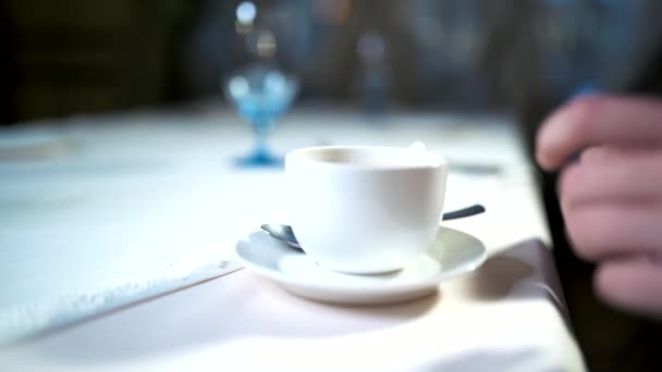 Kezében a fiatal nő vesz egy fehér csésze kávé vagy cappuccino található táblázatból étteremben. Miután kávészünet felismerhetetlen lány. Lassú mozgás — Stock videók