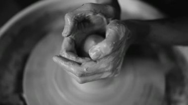 Potter şekiller kil ürün - kulplu testi - seramik araçları ile karşılaştı. Erkek el potters tekerlek üzerinde çalışma kapatın. Seramik vazo bitmedi aletlerden üzerinde dönen bir kadeh. siyah ve beyaz.