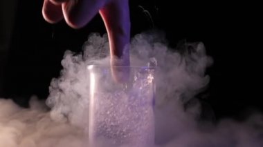 Adam konteyner sıvı azot ile elini koyar. Kavramı kimyasal deneyler ve testler. Edutainment. ağır çekim