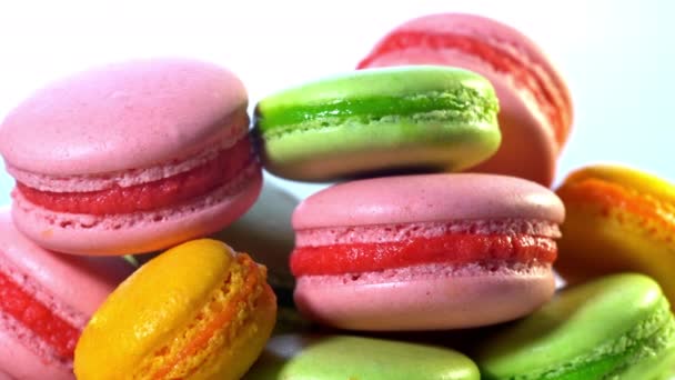 Macarons franceses - biscoitos de merengue com ganache ou recheio de creme de manteiga. Macaroons coloridos girando, visão horizontal, câmera lenta. Cozinhar, comida e cozimento, conceito de pastelaria . — Vídeo de Stock