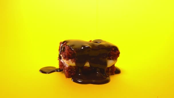 Γλάσο σοκολάτα υπερβάλων ρίχνει στο μπισκότο τούρτα επιδόρπιο σε κίτρινο φόντο. Γλυκιά διακόσμηση. Μαγειρική, τροφή και το ψήσιμο, το concept του καταστήματος ζαχαροπλαστικής. — Αρχείο Βίντεο