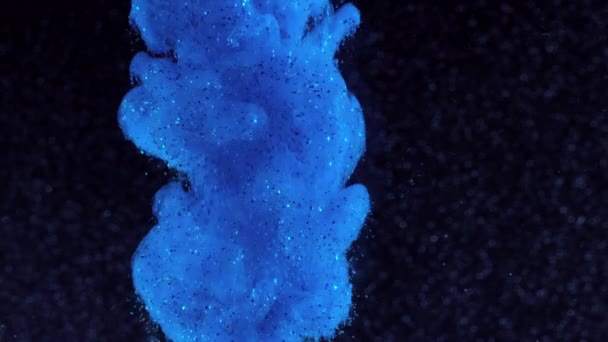 Glitter μελανιού στο νερό. Μπλε χρώμα με αστράφτει σε μαύρη αντίδραση στο νερό δημιουργώντας αφηρημένα σύννεφο σχηματισμούς. Μπορεί να χρησιμοποιηθεί ως μεταβάσεις, πρόσθεσαν στη μοντέρνα σχέδια, τέχνη υπόβαθρα, οτιδήποτε με δημιουργικό — Αρχείο Βίντεο