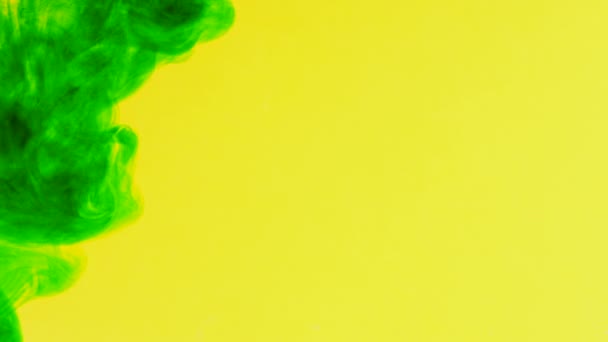 Bläcket i vatten. Grön färg på gul reagerar i vatten skapa abstrakta moln formationer. Kan användas som övergångar, till moderna projekt, konst bakgrunder, något med kreativ twist. — Stockvideo