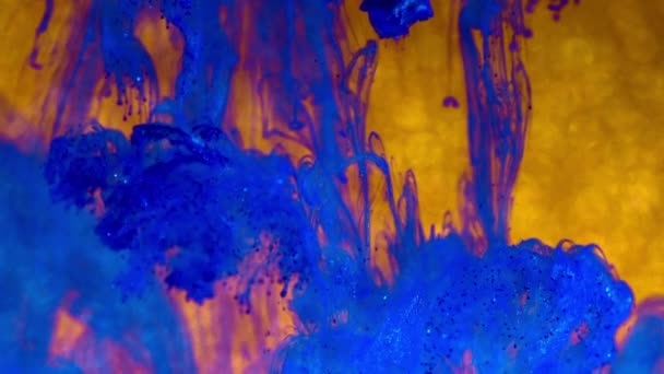 Tinta azul con destellos en agua sobre oro. Pintura brillante reaccionando creando formaciones de nubes abstractas. Fondo brillante. Puede ser utilizado como transiciones, añadido a los proyectos modernos — Vídeo de stock