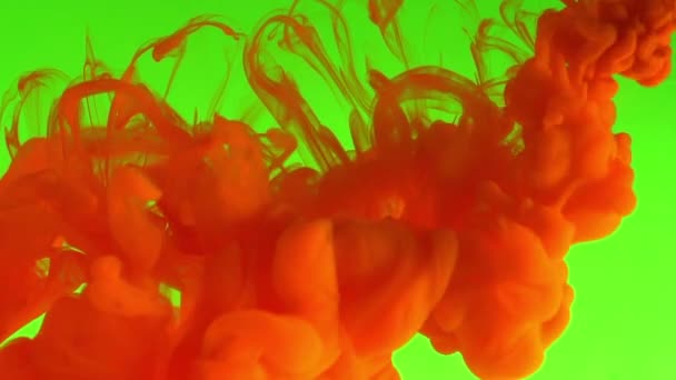 Ink in water. Red paint on acid green reacting in water creating abstract cloud formations.Can be used as transitions,added to modern projects,art backgrounds, anything with creative twist — Stock Video