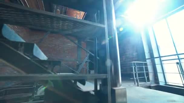 Kamera binadaki inşaat sahasında metal merdiven yukarı taşır. 4k. — Stok video