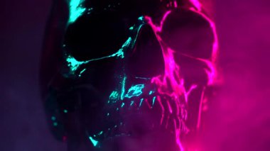 Kırmızı renkli pembe ve turkuaz arka aydınlatma ile koyu arka planda siyah döner ile boyalı insan kafatası modeli. Halloween kutlama, glamour, stil kavramı.