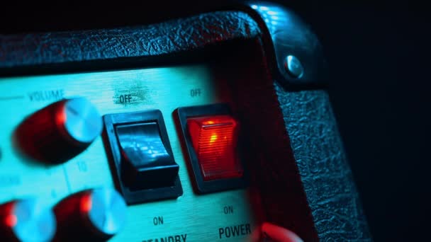 Power switch Tumbler wordt in-en uitgeschakeld door muzikant. Kleurrijke neon licht. Close-up te bekijken. Concert, muziekconcept — Stockvideo