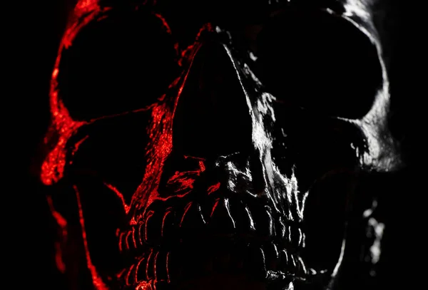 Cabeça de crânio brilhante sobre fundo escuro com luz vermelha néon. Celebração de Halloween, glamour, conceito de estilo. medo e horror . — Fotografia de Stock