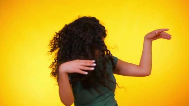 Girl moves to the rhythm of music. Woamn with curly hair dancing on yellow  background. Female having fun. She smiling, hair flutter beautifully.  Amazing positive footage. — Stock Video © kohanova1991 #255353990