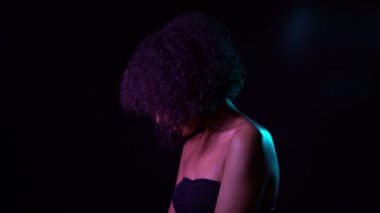 Siyah duvar arka planda kadın portre. Neon ışık ile stüdyoda poz mükemmel sağlıklı cilt ile kız. 4k.