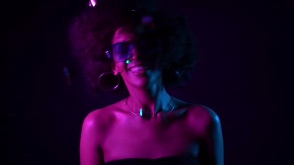 Kıvırcık saçlı dans ve siyah arka planda konfeti yağmur eğlenceli olan genç Afrikalı kız. Kutlama yapan kadın, sevinç ve mutluluğu tasvir ediyor. Başarı, parti, tatil konsepti — Stok video